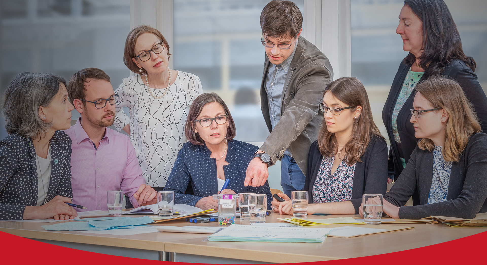 Banner Medizinstudium, Professor Kadmon und ihr Team um einen Tisch mit Dokumenten  (Foto)