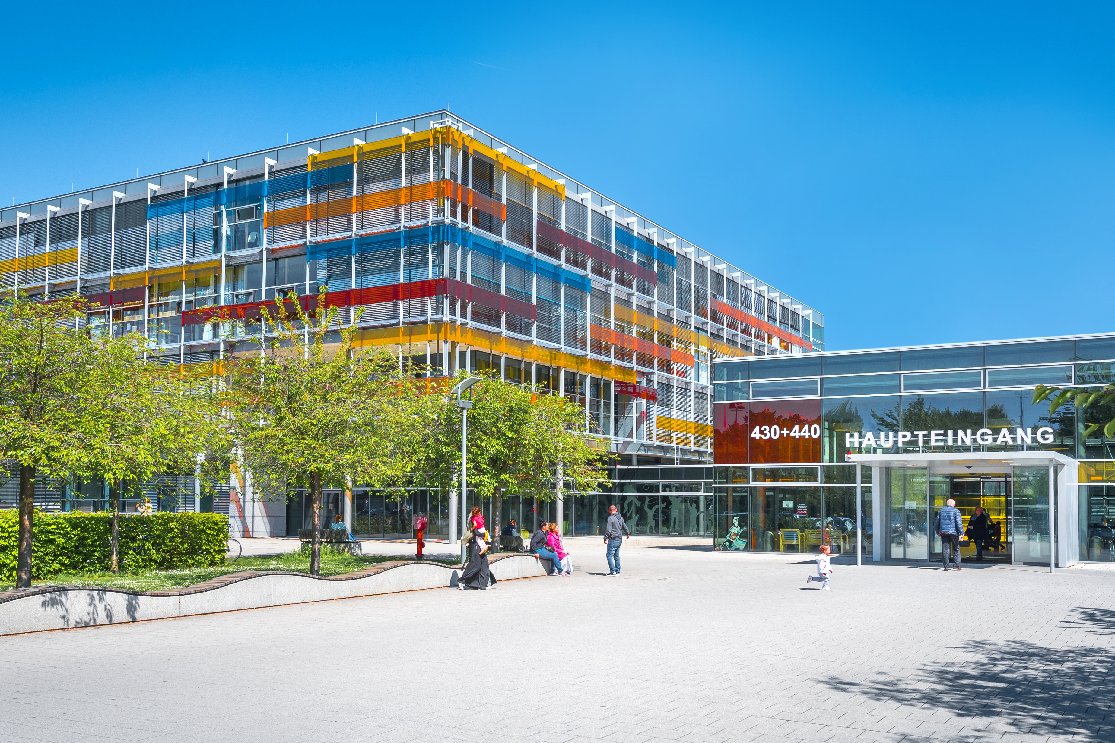 Außenansicht der Kinderklinik mit farbenfroher Glasfassade.