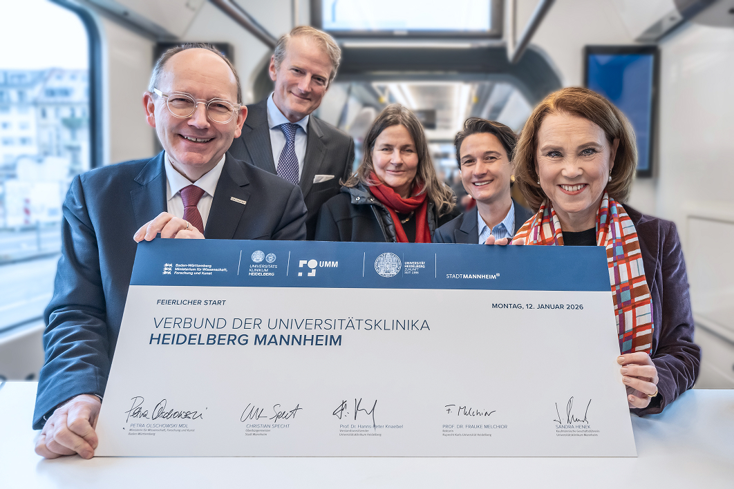 F&uuml;nf Personen pr&auml;sentieren eine unterzeichnete Vereinbarung zum Verbund der Universit&auml;tsklinika Heidelberg und Mannheim.